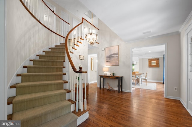 foyer featuring crown molding, a towering ceiling, and hardwood / wood-style floors