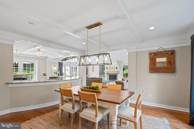 dining room with beam ceiling and hardwood / wood-style floors