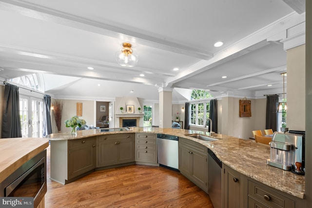 kitchen featuring sink, light wood-type flooring, beamed ceiling, stainless steel appliances, and decorative columns