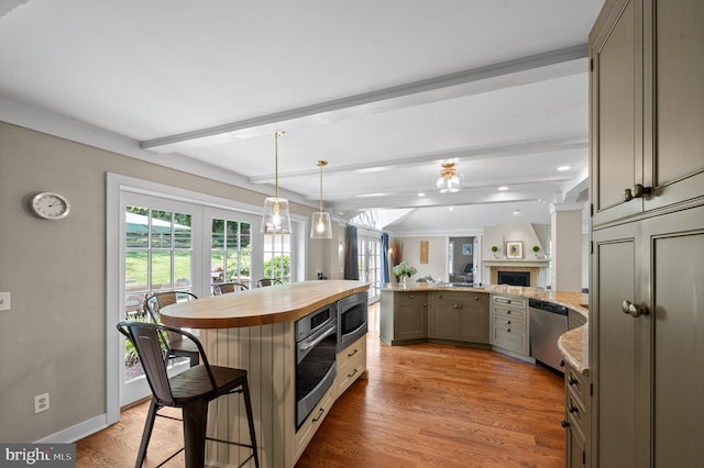 kitchen with gray cabinets, appliances with stainless steel finishes, a kitchen bar, a center island, and beam ceiling