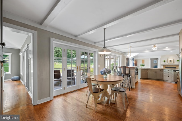 dining room with french doors, beam ceiling, light hardwood / wood-style floors, and a wealth of natural light