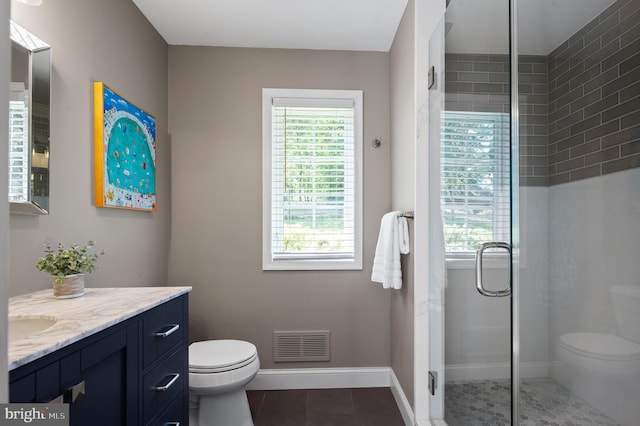 bathroom featuring tile patterned flooring, vanity, a shower with door, and toilet