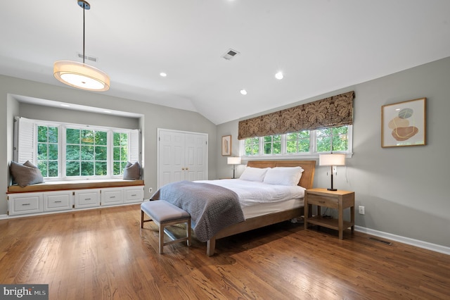 bedroom with multiple windows, hardwood / wood-style flooring, and lofted ceiling