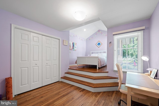 bedroom featuring vaulted ceiling, hardwood / wood-style floors, and a closet