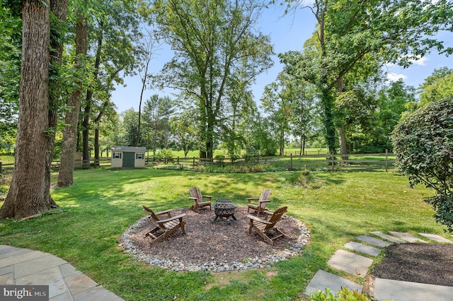 view of yard featuring a shed and an outdoor fire pit