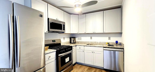 6011 Emerson St Unit 307, Bladensburg, MD 20710 - kitchen with appliances with stainless steel finishes, white cabinetry, ceiling fan, light stone countertops, and light hardwood / wood-style flooring