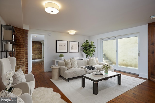 living room featuring brick wall and dark hardwood / wood-style floors