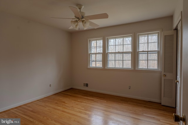 empty room with ceiling fan and light hardwood / wood-style floors