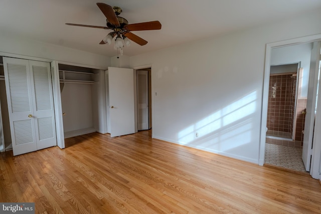 unfurnished bedroom featuring ceiling fan, connected bathroom, light hardwood / wood-style flooring, and two closets