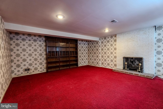 basement featuring a brick fireplace and carpet