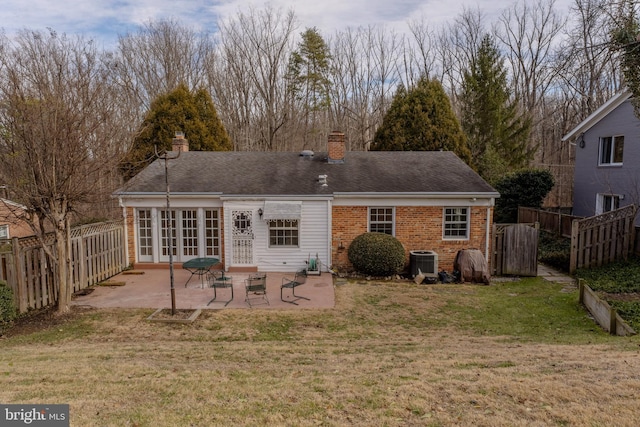 rear view of property with cooling unit, a patio area, a lawn, and french doors