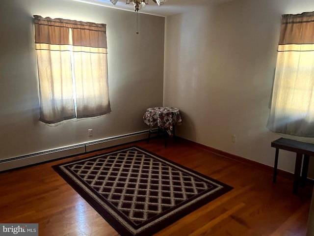 empty room with a baseboard radiator and hardwood / wood-style floors