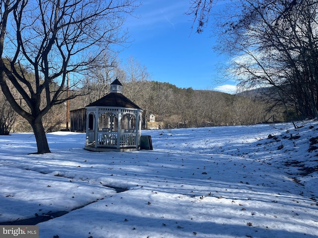 yard layered in snow featuring a gazebo