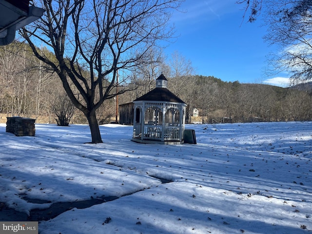 snowy yard featuring a gazebo