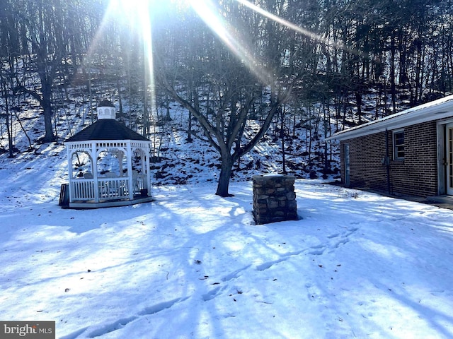 yard covered in snow featuring a gazebo