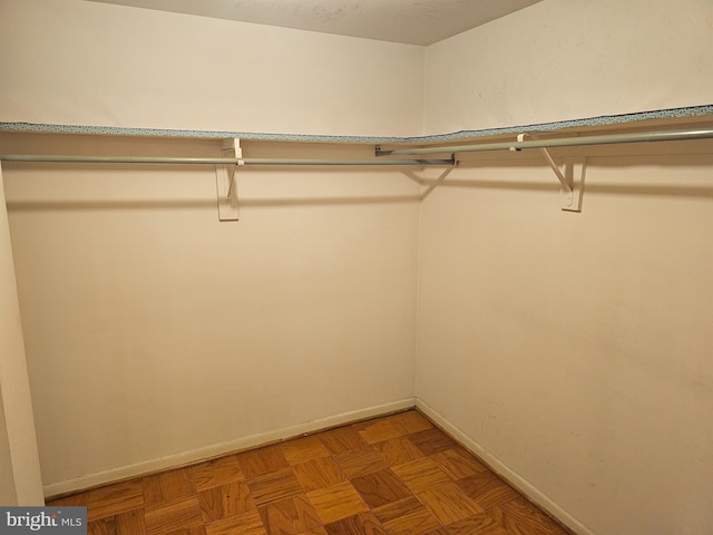 walk in closet featuring parquet floors