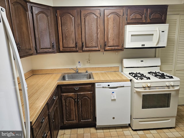 kitchen with white appliances, sink, and dark brown cabinets