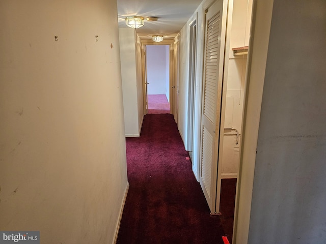 corridor featuring dark colored carpet