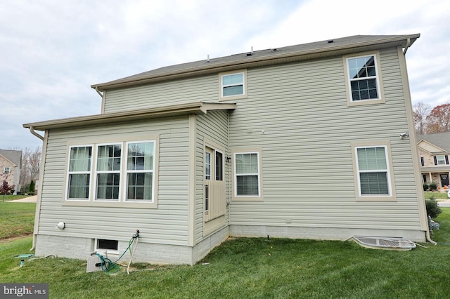 rear view of house featuring a lawn