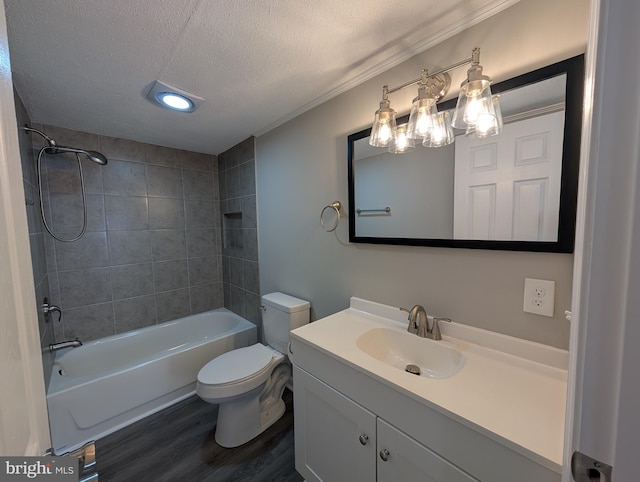 full bathroom with tiled shower / bath, hardwood / wood-style flooring, vanity, toilet, and a textured ceiling