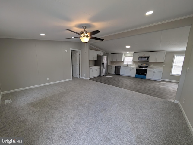 unfurnished living room featuring ornamental molding, sink, light colored carpet, and ceiling fan