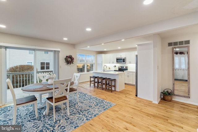 dining room with sink and light hardwood / wood-style flooring