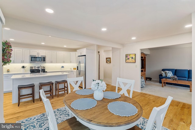 dining room with sink and light wood-type flooring