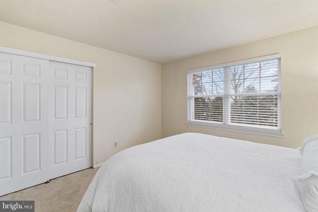 bedroom with light carpet and a closet