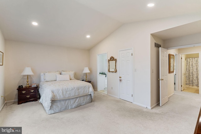 bedroom featuring lofted ceiling, light carpet, and ensuite bathroom