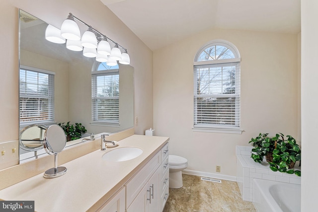 bathroom featuring a washtub, vanity, plenty of natural light, and vaulted ceiling