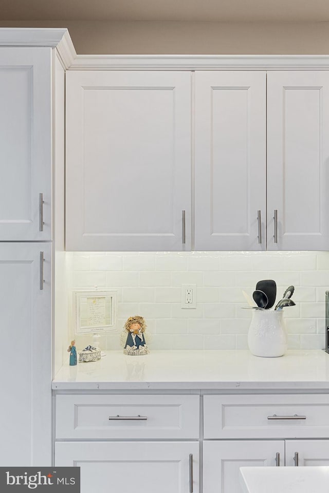 bar featuring white cabinetry and decorative backsplash