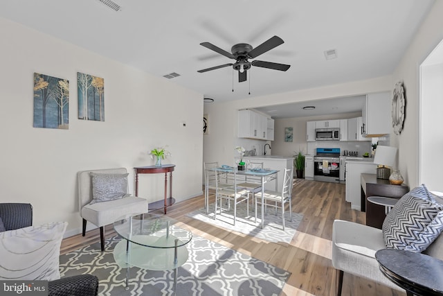 living room featuring ceiling fan and light wood-type flooring