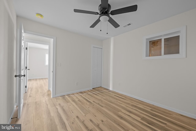 unfurnished bedroom with light hardwood / wood-style floors, a closet, and ceiling fan