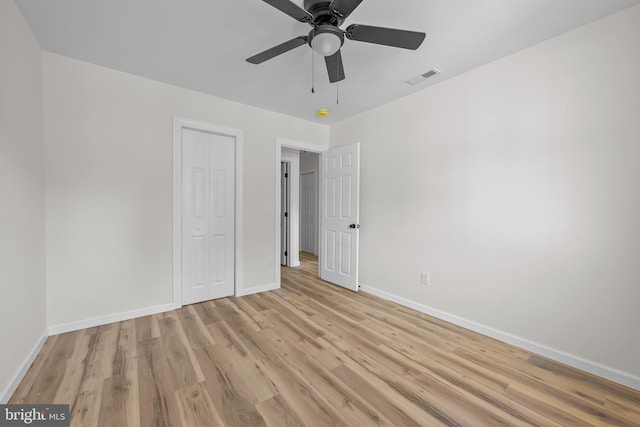 unfurnished bedroom with ceiling fan, light hardwood / wood-style floors, and a closet