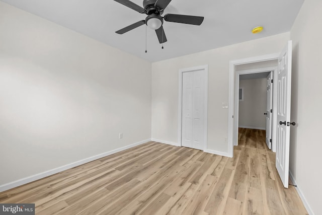 unfurnished bedroom featuring ceiling fan, light hardwood / wood-style floors, and a closet