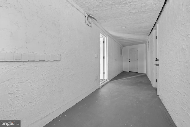 corridor featuring concrete floors and a textured ceiling