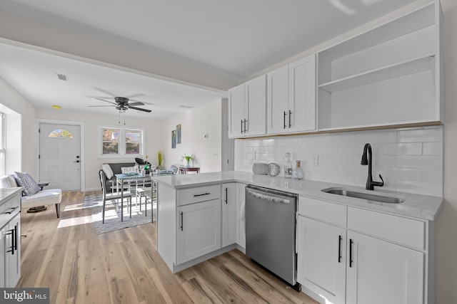 kitchen featuring white cabinetry, sink, stainless steel dishwasher, kitchen peninsula, and light wood-type flooring