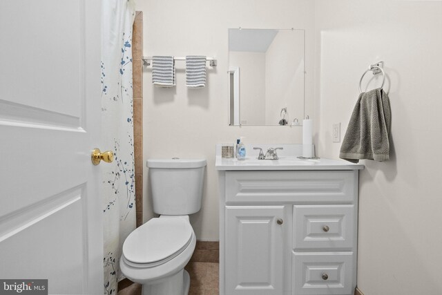 bathroom with a shower with curtain, vanity, toilet, and tile patterned flooring