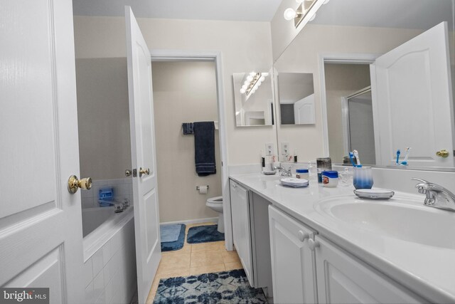 bathroom featuring vanity, tiled tub, tile patterned floors, and toilet