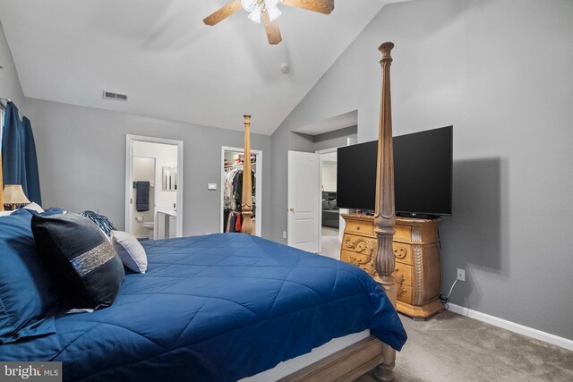 bedroom featuring vaulted ceiling, ensuite bathroom, a walk in closet, carpet, and a closet