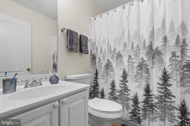 bathroom featuring a shower with curtain, vanity, and toilet