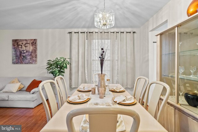 dining area with an inviting chandelier and dark wood-type flooring