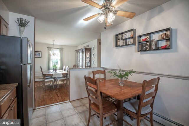 tiled dining room with ceiling fan and a baseboard radiator