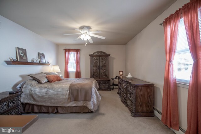 carpeted bedroom with a baseboard heating unit and ceiling fan