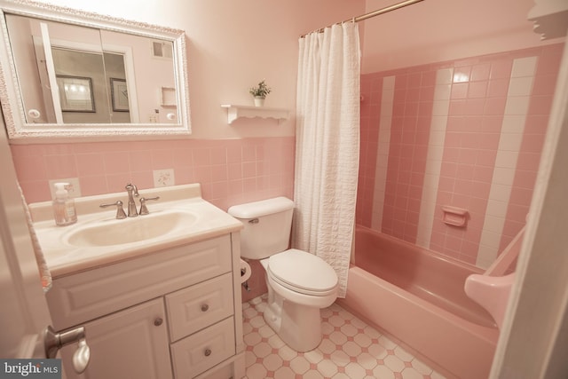 full bathroom featuring tile walls, vanity, toilet, and shower / bathtub combination with curtain