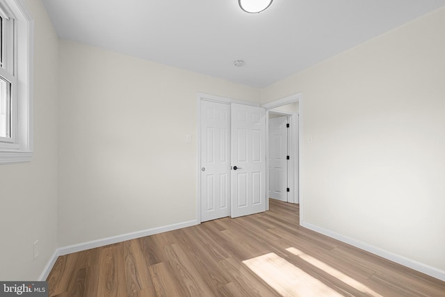 unfurnished bedroom with a closet and light hardwood / wood-style flooring