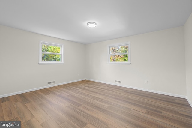 spare room with a healthy amount of sunlight and light hardwood / wood-style flooring