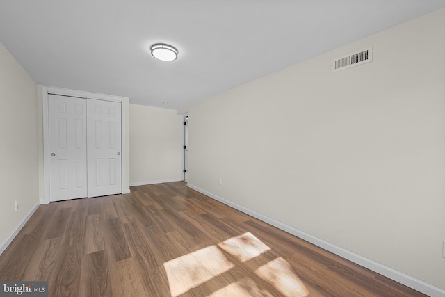 unfurnished bedroom with dark wood-type flooring and a closet