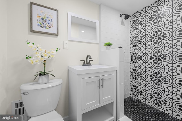 bathroom featuring vanity, tiled shower, and toilet