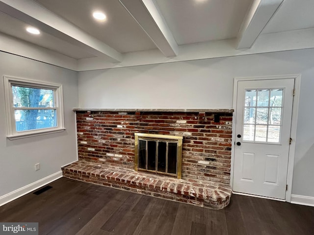 unfurnished living room featuring beamed ceiling, a fireplace, and dark wood-type flooring